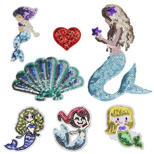 May include: A selection of sequined mermaid and seashell patches in various colours. The mermaids have different hair colours and poses, with blue, purple, and green tails. A red sequined heart is also included. These patches are ideal for embellishing clothing or accessories.