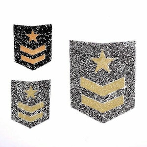 Op de afbeelding: Drie glitterende patches in zwart en goud. Elke patch heeft een gouden ster en gouden chevrons. De patches zijn in verschillende maten, met een zwarte achtergrond en gouden accenten. De patches staan op een witte achtergrond.