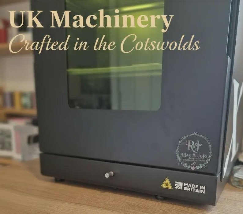 Puede incluir: M&aacute;quina negra con ventana de cristal, con el texto "UK Machinery Crafted in the Cotswolds". La m&aacute;quina tiene un logotipo "Riley & Jojo" y una etiqueta "Made in Britain". Tambi&eacute;n es visible un s&iacute;mbolo de advertencia.