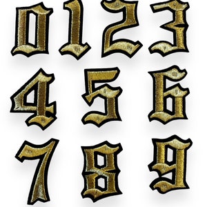 Peut inclure: Ensemble de dix patchs thermocollants brodés dorés représentant les chiffres de 0 à 9 dans un style de police gothique.