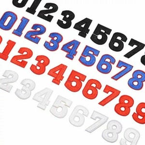 Puede incluir: Un conjunto de números para planchar en negro, azul, rojo y blanco. Los números van del 0 al 9.