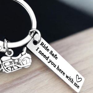 May include: Silver motorcycle keychain with a tag that reads "Ride Safe I need you here with me" and a heart symbol.