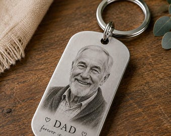 May include: A silver-toned metal dog tag keychain featuring a laser-engraved portrait of an older man with a beard. Below the portrait, the text reads DAD forever in my heart, flanked by two small heart symbols. The keychain has a circular ring.