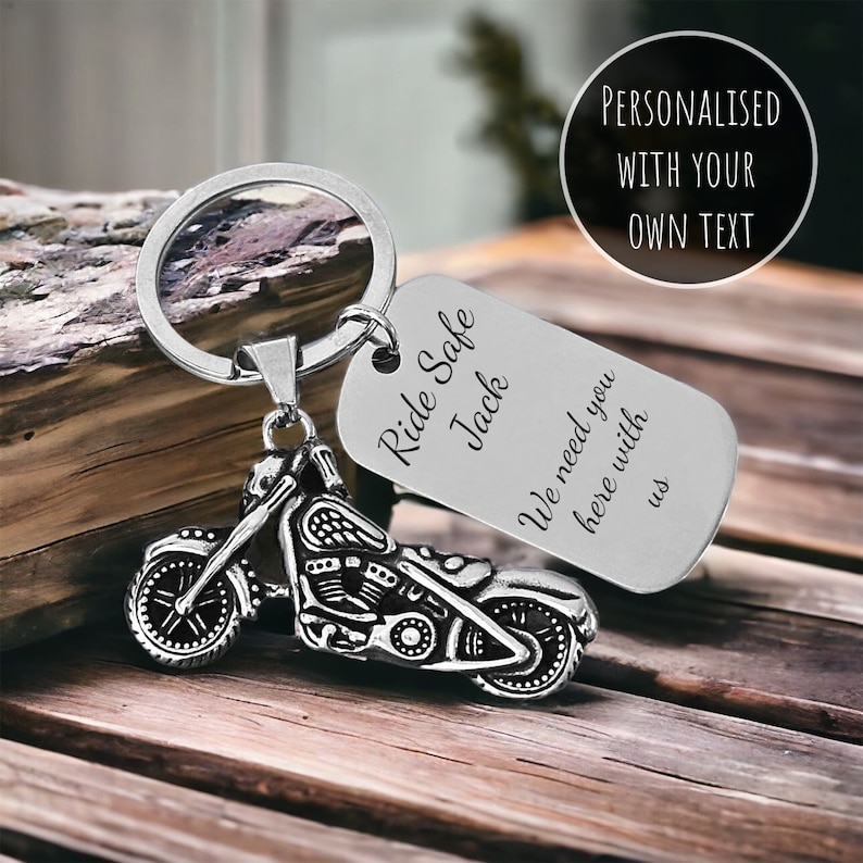 May include: A silver motorcycle keychain with a rectangular tag. The tag reads "Ride Safe Jack, We need you here with us." The keychain also has the text "Personalised with your own text" in a circle.