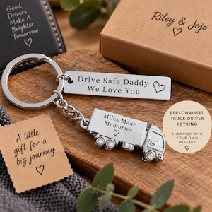 May include: A silver metal keyring featuring a rectangular tag engraved with "Drive Safe Daddy We Love You" and a truck-shaped charm engraved with "Miles Make Memories" with a heart symbol, accompanied by a brown gift box and note cards.