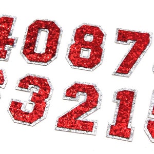 May include: Red glitter iron-on numbers with a white outline. The numbers are 1, 0, 8, 7, 3, 2, 1, and 5.