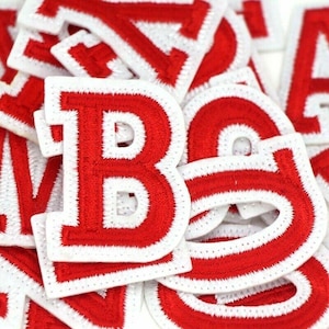 Op de afbeelding: Rode vilt letters met witte randen. De letter B is in het midden van de afbeelding.