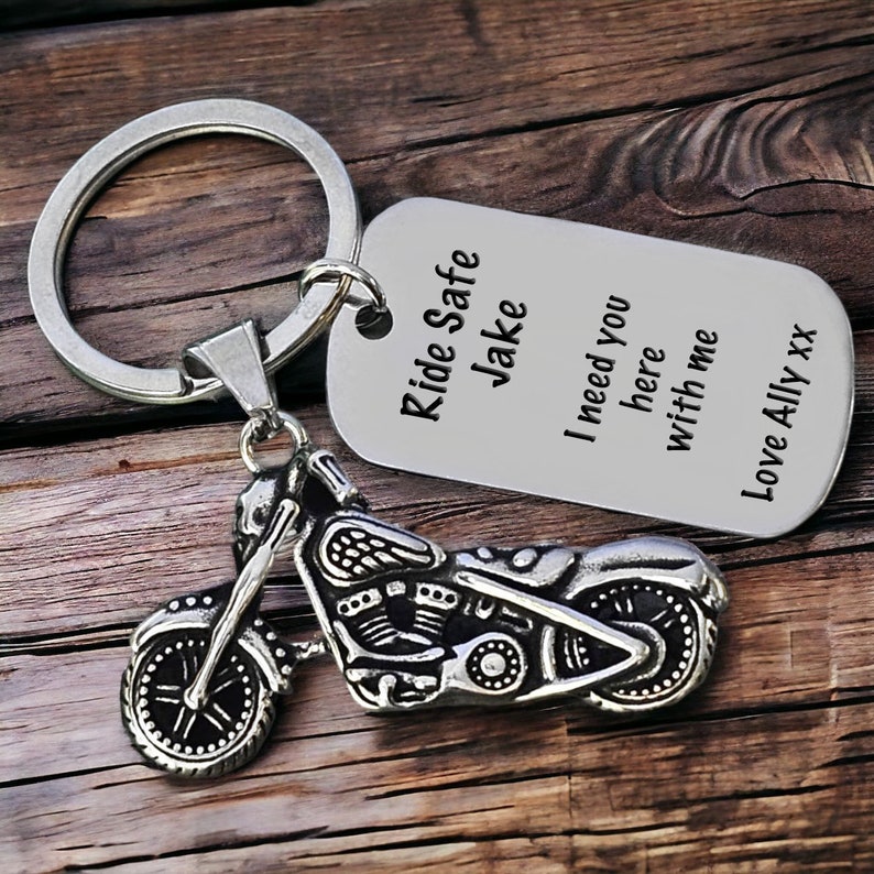 May include: A silver motorcycle keychain with a dog tag. The tag reads "Ride Safe Jake" and "I need you here with me, Love Ally xx". The motorcycle charm is detailed with engine and wheel features.
