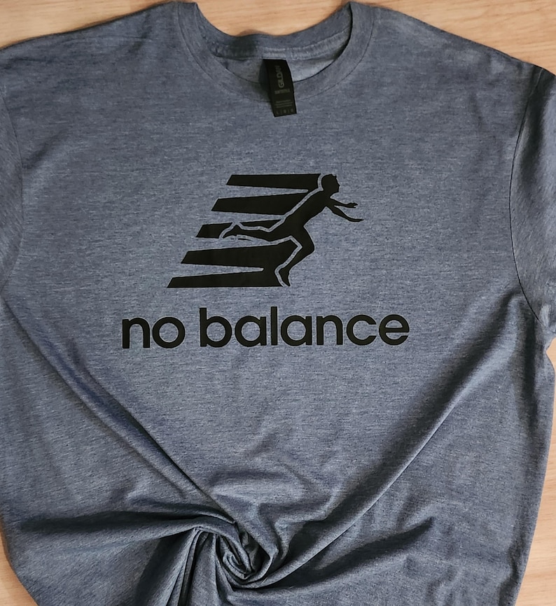 May include: A blue t-shirt with a black graphic of a person running on a set of stairs. The text "no balance" is printed below the graphic.