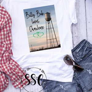 May include: White t-shirt with a graphic of a water tower and the text "Billy Bob loves Charlene" with two green hearts.