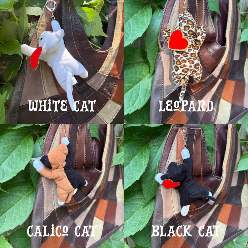 K&ouml;nnte beinhalten: Vier Pl&uuml;schtier-Schl&uuml;sselanh&auml;nger an einer braunen Patchwork-Ledertasche. Die Kollektion umfasst eine wei&szlig;e Katze, eine Leopardenkatze, eine Gl&uuml;ckskatze und eine schwarze Katze, jeweils mit einem kleinen roten herzf&ouml;rmigen Akzent auf der Brust.
