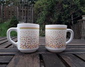 Pair of vintage arcopal coffee mugs. Spots and stripes pattern in pink yellow and green. Milk glass, Opalware. Made in France