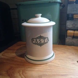 May include: White ceramic pasta jar with a green lid and green trim. The jar has the word "PASTA" written in green letters on the front.