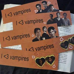 May include: Five orange bookmarks with the text "I <3 vampires" printed in black. Each bookmark features a different image of a vampire from a popular television show. The bookmarks are decorated with hearts and glitter.
