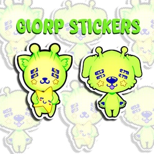 Op de afbeelding: Twee limoengroene cartoon wezen stickers met donkerblauwe rechthoekige ooglapjes met witte sterren. Het ene wezen houdt een gele ster vast, het andere heeft een blauwe neus en tong. De tekst GIORP STICKERS staat in het groen erboven.