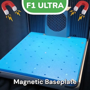 May include: A blue magnetic baseplate with a grid of holes for a 3D printer. The baseplate is labeled "Magnetic Baseplate" and is part of an F1 Ultra 3D printer.