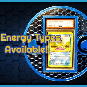 May include: A graded Pokemon card featuring Squirtle from the 1999 Pokemon Game set. The card is in a protective case and has a Gem Mint 10 rating. The text "11 Energy Types Available!" is displayed in yellow letters on a blue background.