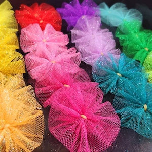 May include: A collection of colorful tulle bows in various shades of yellow, red, purple, light blue, green, pink, and teal. The bows are made of soft, delicate tulle and are perfect for adding a touch of whimsy to any project.