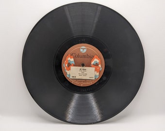 Può includere: Un disco in vinile nero vintage con un'etichetta marrone e bianca. L'etichetta recita "All Alone" di The Cavaliers, con il logo Columbia. Il disco è un 78 giri, un formato musicale classico.