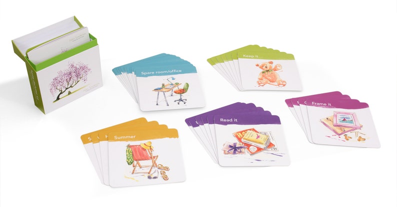 K&ouml;nnte beinhalten: Ein Satz bunter Karten mit Illustrationen und Text. Die Karten sind in Stapeln mit verschiedenen farbigen R&auml;ndern angeordnet. Der Text auf den Karten lautet "Summer", "Spare room/office", "Keep it", "Read it" und "Frame it".