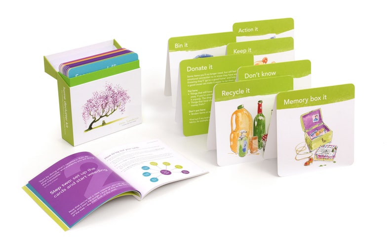 K&ouml;nnte beinhalten: Ein Satz gr&uuml;ner und wei&szlig;er Karten mit Illustrationen und Text. Die Karten befinden sich in einer Schachtel mit gr&uuml;nem und wei&szlig;em Design. Die Schachtel zeigt ein Bild eines Baumes mit rosa Bl&uuml;ten. Der Text auf den Karten lautet "Action it", "Bin it", "Keep it", "Donate it", "Don't know", "Recycle it" und "Memory box it".