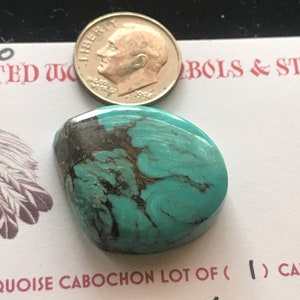 May include: A turquoise cabochon gemstone with black veins, measuring 34.0 carats. The stone is shown next to a US dime for size comparison.  The text "QUOISE CABOCHON LOT OF (1) CABS" and "cts. 34.0 CC." is visible in the image.
