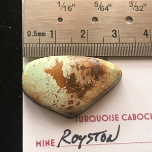May include: A turquoise cabochon with brown matrix, measuring approximately 3/32 inches, from the Royston Mine.