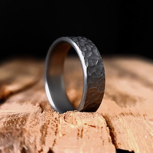 May include: A silver hammered wedding band with a textured finish.