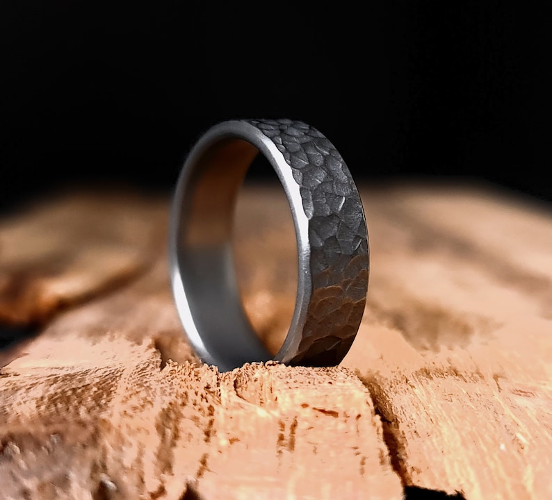 May include: A silver hammered wedding band with a textured finish.