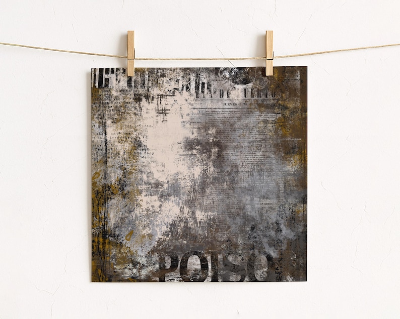 May include: Square abstract art print with a distressed, textured design. The artwork features a mix of neutral colours, including brown, grey, and white, with visible text elements and the word "POISON" in large, bold letters. The print is held by wooden clips.
