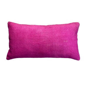 May include: A bright pink rectangular cushion with a soft, textured fabric.