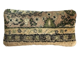 May include: A rectangular pillow with a brown, green, and black patterned fabric. The fabric has a fuzzy texture.