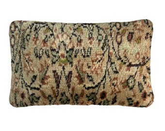 May include: A rectangular pillow with a beige background and a floral pattern in shades of brown, green, and black.