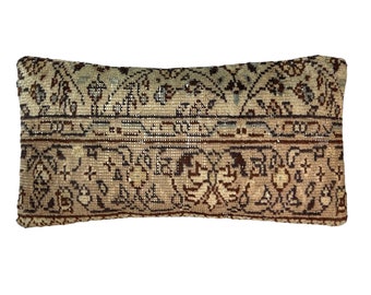 May include: A rectangular throw pillow with a beige background and a brown, black, and blue floral pattern.