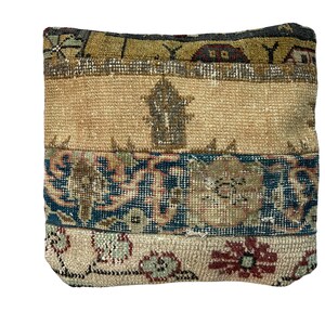 May include: A square throw pillow with a beige, blue, and red patterned fabric. The pillow is made from a woven fabric with a vintage look.