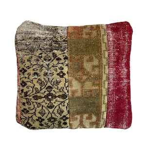 May include: A square pillow with a patchwork design. The pillow is made of different pieces of fabric with floral and geometric patterns in shades of brown, beige, green, and red.