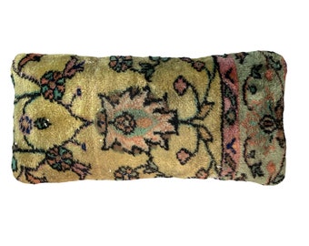 May include: A rectangular pillow with a floral pattern in shades of green, pink, and black. The pillow is made from a soft, plush fabric.