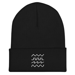 May include: Black beanie with a white embroidered design of wavy lines and a square wave pattern.