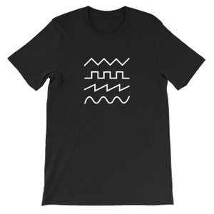 May include: Black t-shirt featuring a white graphic of four different wave patterns. The design includes a zigzag, a square wave, a sawtooth wave, and a sine wave. The shirt is a crew neck and has short sleeves.