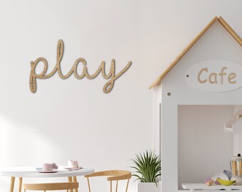 May include: A white playhouse with a sign that says "Cafe" and a wooden sign that says "play" on the wall behind a white table and chairs.