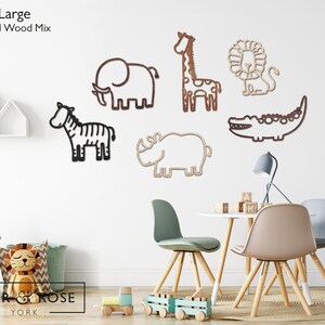 K&ouml;nnte beinhalten: Holz-Wanddekorationen mit Tieren, darunter ein Elefant, eine Giraffe, ein L&ouml;we, ein Zebra, ein Nashorn und ein Krokodil. Die Tiere sind in einem einfachen Umrissstil in Braun- und Schwarzt&ouml;nen gehalten. Der Text "Extra Large Standard Wood Mix" ist zu sehen.