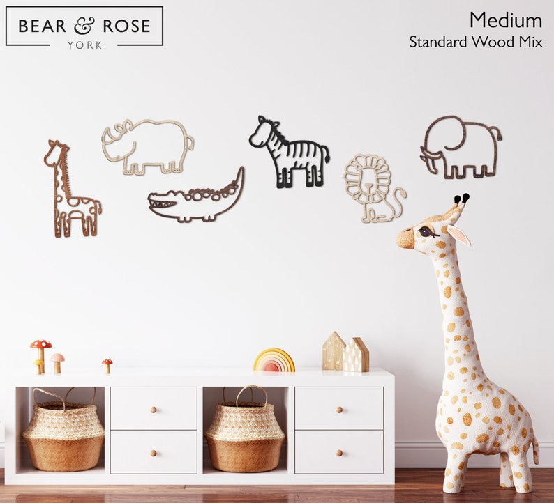 K&ouml;nnte beinhalten: Holz-Wanddekorationen mit Tieren: Giraffe, Nashorn, Zebra, Krokodil, L&ouml;we und Elefant. Die Giraffe ist gefleckt, die anderen Tiere sind aus Holz. Der Text "BEAR & ROSE YORK" ist sichtbar. Mittlere Gr&ouml;&szlig;e.