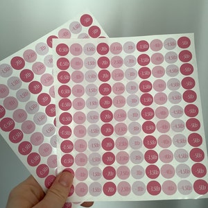May include: Two sheets of pink and light pink round stickers with weight loss measurements in pounds. Each sticker has a number from -0.23kg to -2.27kg. The stickers are on a white background.