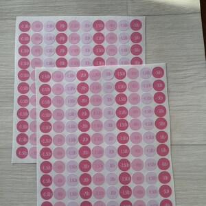 May include: Two sheets of round stickers in varying shades of pink. Each sticker is labelled with a weight in pounds, ranging from -0.5lb to -5lb. The stickers are designed for tracking weight loss.
