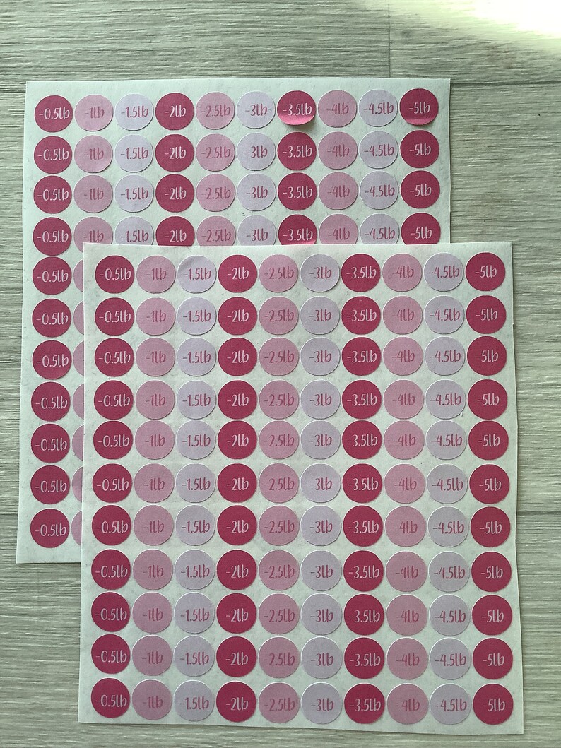 May include: Two sheets of pink and magenta weight loss stickers. Each sticker is a circle with a weight loss amount in pounds, ranging from -0.5lb to -5lb.