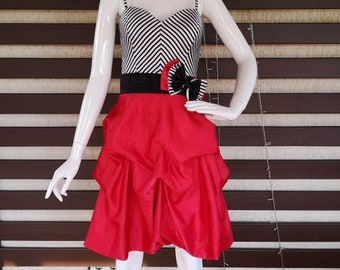 May include: A red and black striped dress with a black bow and a red ruffled skirt.