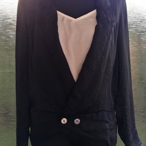 May include: A black satin blazer with a deep V-neckline and two silver buttons. The blazer has long sleeves and a relaxed fit.