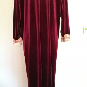 May include: A long, burgundy velvet robe with gold embroidery on the cuffs.