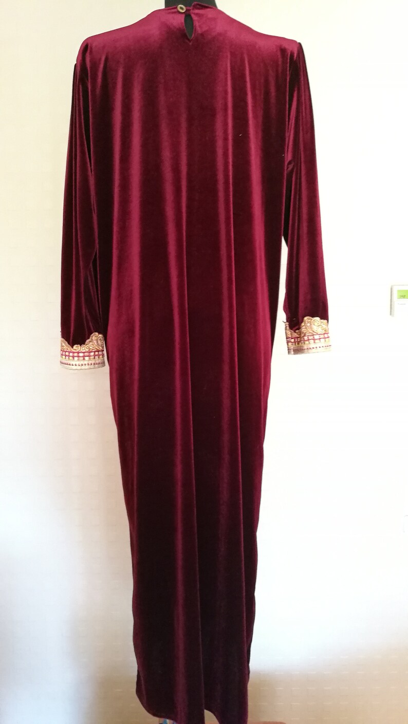 May include: A long, burgundy velvet robe with gold embroidery on the cuffs.
