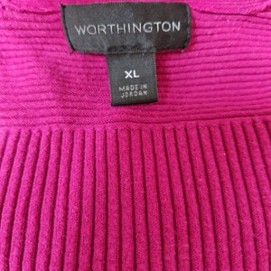 May include: A magenta ribbed sweater with a black tag that reads "Worthington" and "XL Made in Jordan."